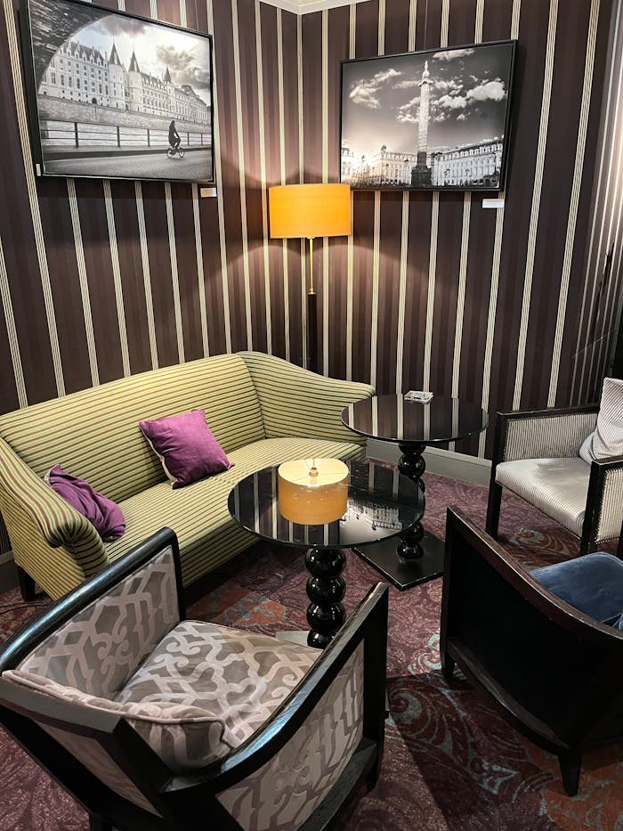 Stylish hotel lounge in Paris featuring elegant furniture and artistic decor under warm lighting.